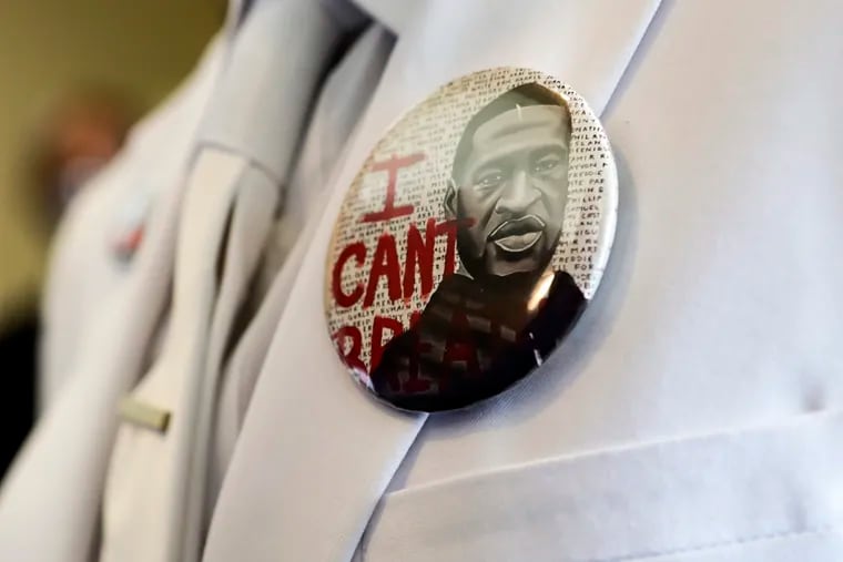 A button that reads “I can't breathe” adorned the jacket of a mourner before the funeral for George Floyd in Houston in June 2020.