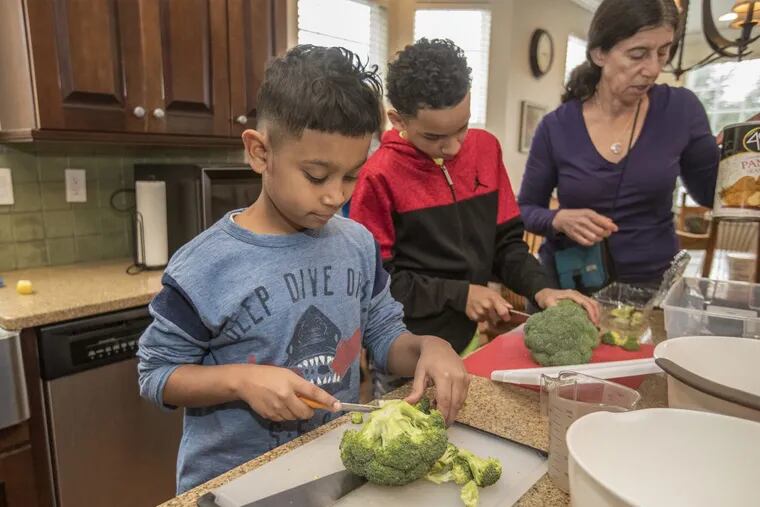 Noah McBride (left), 11,  and Jaden Mosely, 10, cut up broccoli.