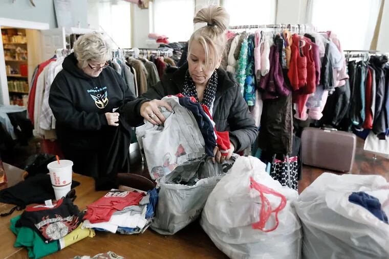 Michele Gambone (right) and Jeanne Rodrigues sort donations that came in on the charity’s Facebook page.