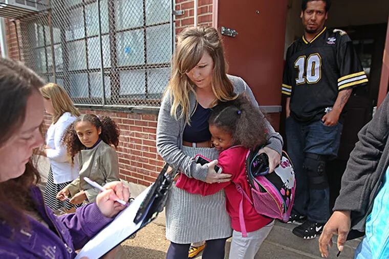 Brianne Steakelum, Dean of Students at City Invincible Charter School, center, gets a hug from Harmony Bronson, 7, right, as students leave school on Thursday, May 8, 2014.  ( Michael Bryant / Staff Photographer )
