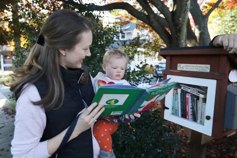 Megan Patterson and her daughter Edie Patterson borrow The 12 Days of Christmas from Chris Swisher's Little Free Library at 237 Lenoir Ave., Wayne, PA, Thursday November 8, 2018.