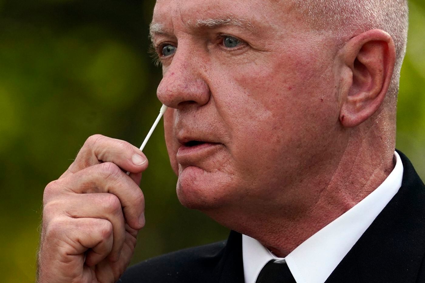 Adm. Brett Giroir, assistant secretary of Health and Human Services, swabs his nose as he demonstrates a new fast result COVID-19 antigen test during an event with President Donald Trump at the White House on Monday. (AP Photo/Evan Vucci)Evan Vucci / AP