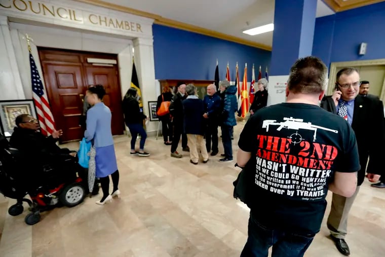 Dennis Jordan, right, a Pittsburgh resident, wears a shirt supporting the 2nd Amendment as he waits with others to attend a Pittsburgh City Council meeting regarding proposed gun restriction legislation, Tuesday, April 2, 2019, in Pittsburgh. A universal background checks bill approved by the U.S. House awaits a vote in the Senate.