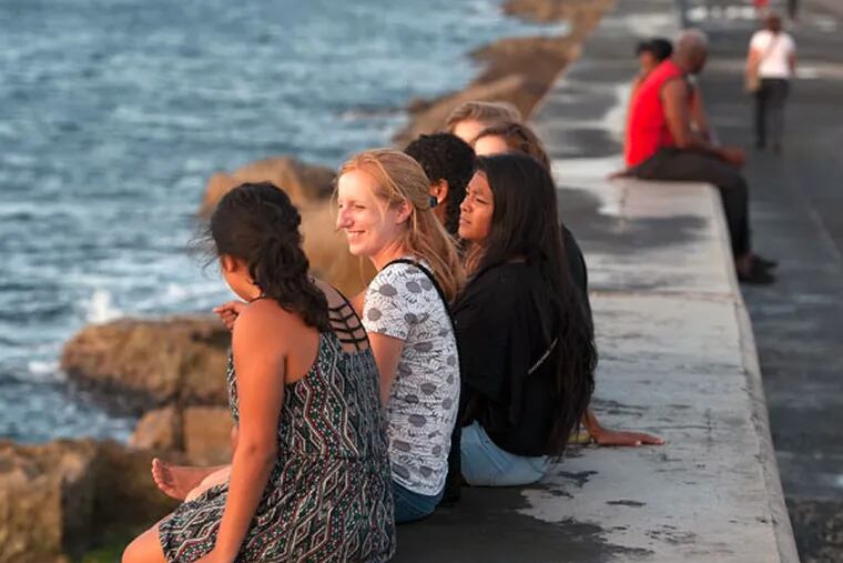 Student participants in Arcadia University’s semester abroad in Havana, including Janelle Crilley (second from left) and Jessica Perez (third from left), enjoy a sunset. Many U.S. colleges offer Cuban study; only Aracadia has a presence in fall, spring, and summer. (CLEM MURRAY / Staff Photographer)