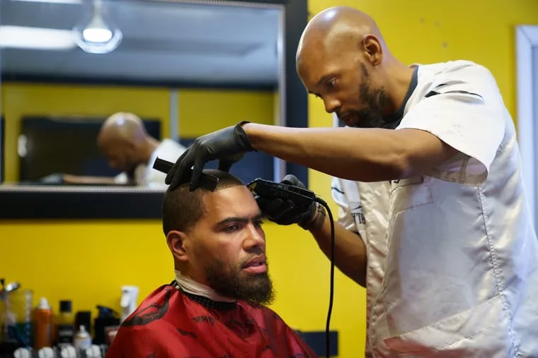 Jamel Workman cuts the hair of his former cellmate Terrance Lewis at his barbershop in West Philadelphia in June 2019. Lewis had recently been released from prison after serving 21 years for a murder he did not commit.