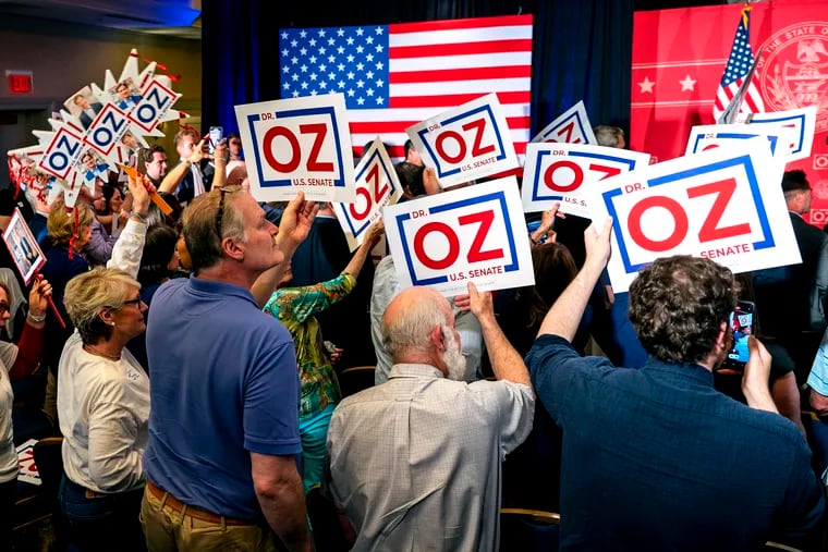 Awaiting his arrival onstage, supporters hold signs for Republican candidate for the U.S. Senate Mehmet Oz as he campaigns in King of Prussia June 9, 2022.