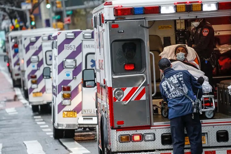 FILE - In this Monday, April 13, 2020, file photo, a patient arrives in an ambulance cared for by medical workers wearing personal protective equipment due to COVID-19 coronavirus concerns outside NYU Langone Medical Center in New York. (AP Photo/John Minchillo, File)