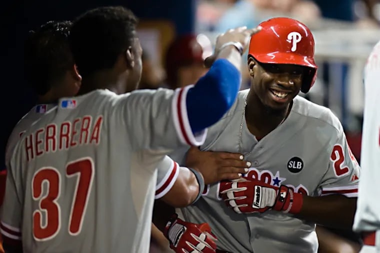 Philadelphia Phillies pinch hitter Darnell Sweeney (C) celebrates with teammates after hitting a solo home run during the eighth inning against the Miami Marlins at Marlins Park.