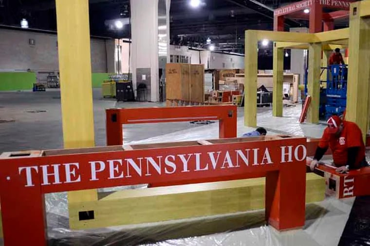 Workers  assemble the Pennsylvania Horticultural Society booth at Hawaii: Islands of Aloha theme of the 2013 Philadelphia International Flower Show. TOM GRALISH / Staff Photographer )