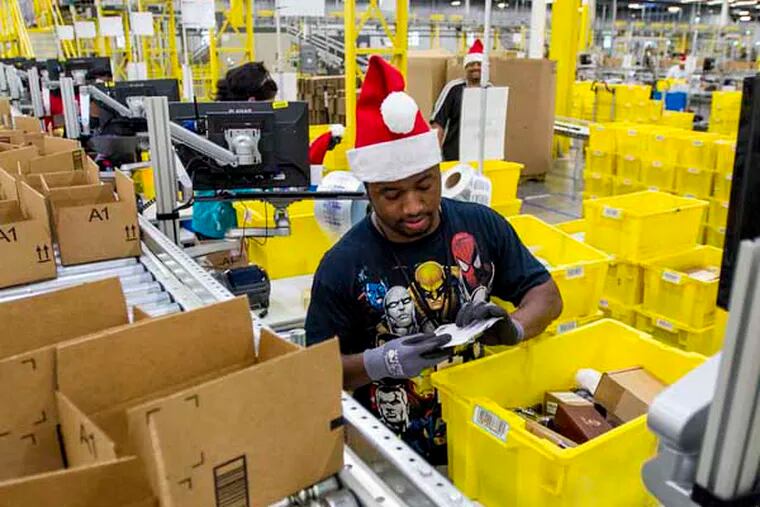 Amazon.com Inc. employees load boxes with orders at the company's fulfillment center ahead of Cyber Monday in Tracy, California, U.S., on Sunday, Nov. 30, 2014  Photographer: David Paul Morris/Bloomberg