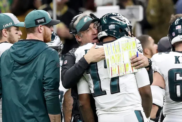 Doug Pederson offers some encouraging words to Alshon Jeffery after the Saints intercepted a pass intended for the receiver as Carson Wentz (left) stands nearby.