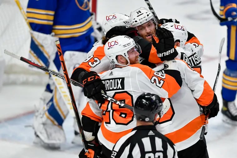 The Flyers' Claude Giroux (28) and Sean Couturier (14) celebrate with teammates after Couturier's game-tying goal late in the third period Monday. The Flyers beat Buffalo in overtime, 4-3.
