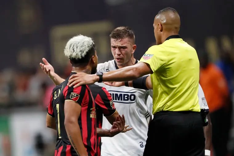 An official steps between Atlanta United forward Josef Martinez (7) and Union defender Kai Wagner (27) as they exchange words during the first half of Thursday's Eastern Conference semifinal .