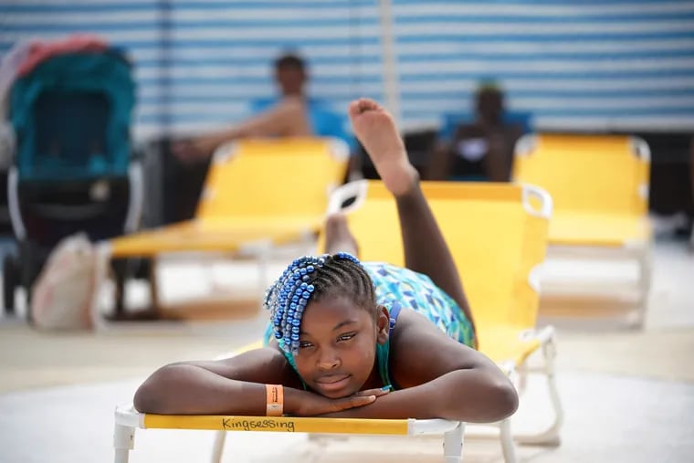 Makayla Thomas rests on a lounge chair by the pool at the Kingsessing Rec Center, in Philadelphia, July 2, 2019. $3,000 was raised for new pool chairs, a blue and white striped privacy screen, umbrellas, a new shower head, and concrete paint, to spruce up the community pool.