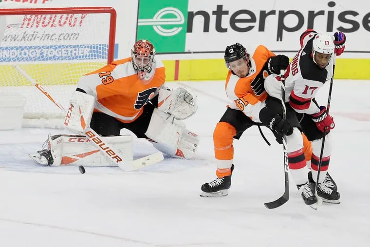 Flyers goalie Carter Hart making a save as defenseman Justin Braun (61) keeps New Jersey's Wayne Simmonds from getting the rebound in the first period Wednesday. The Flyers improved to 2-0 with a 4-0 win.