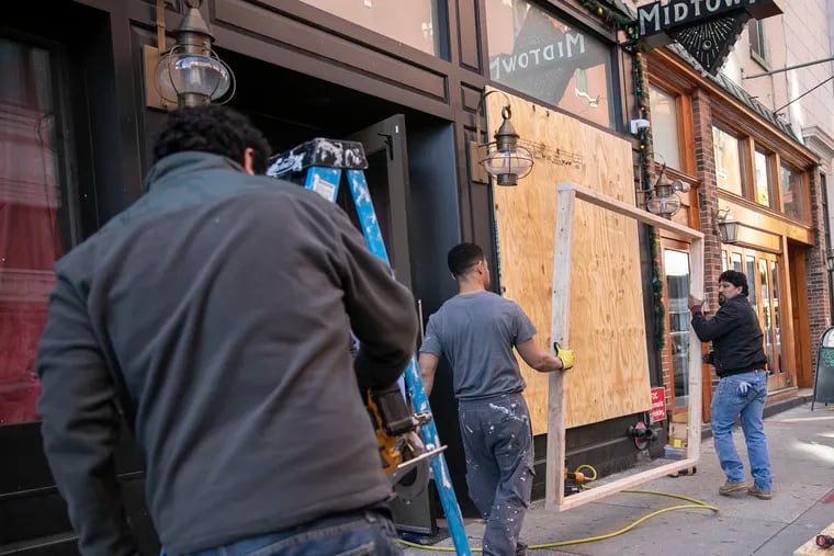 Workers from Philadelphia Custom Builders board up the popular Tinsel bar in Center City on Saturday, March 21, 2020. Gov. Tom Wolf called for the closure of all businesses that are not "life-sustaining," due to the spread of the coronavirus. Restaurants are now takeout or delivery only.