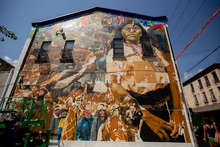 The mural "Sanctuary City, Sanctuary Neighborhood" on the side of the Providence Center in Fairhill by Chilean artist, Ian Pierce in 2019.