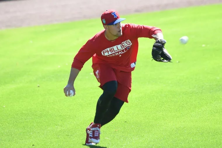 Scott Kingery fields balls during spring training workouts, where he is a non-roster invitee.