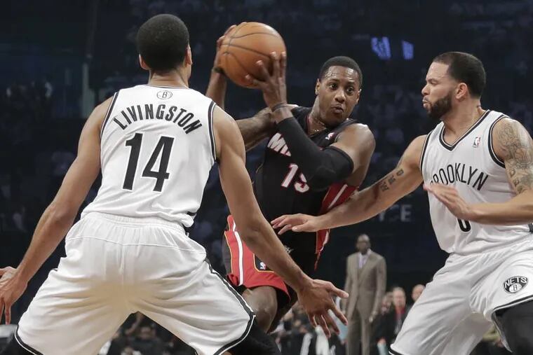 Miami Heat guard Mario Chalmers (15) drives against Brooklyn Nets guards Shaun Livingston (14) and Deron Williams (8) in the second period during Game 3 of an Eastern Conference semifinal NBA playoff basketball game on Saturday, May 10, 2014, in New York. (AP Photo/Julie Jacobson)