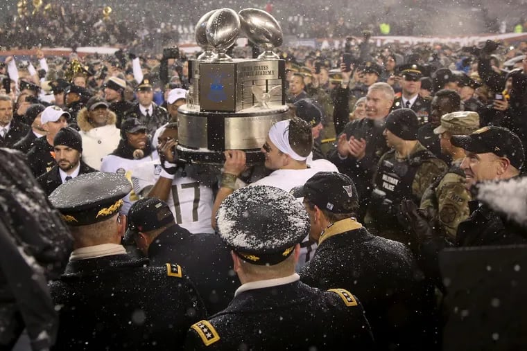 Army players celebrate with the Commander-in-Chief’s Trophy after the annual Army-Navy football game on Saturday at Lincoln Financial Field. Army won, 14-13.