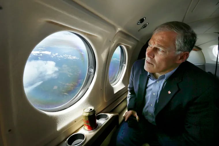 In this July 18, 2014 file photo, Washington Gov. Jay Inslee views the Chiwaukum Creek Fire near Leavenworth, Wash., from the air. Inslee is adding his name to the growing 2020 Democratic presidential field. The 68-year-old is announcing his bid Friday, March 1, 2019, in Seattle after recent travels to two of the four early-nominating states.