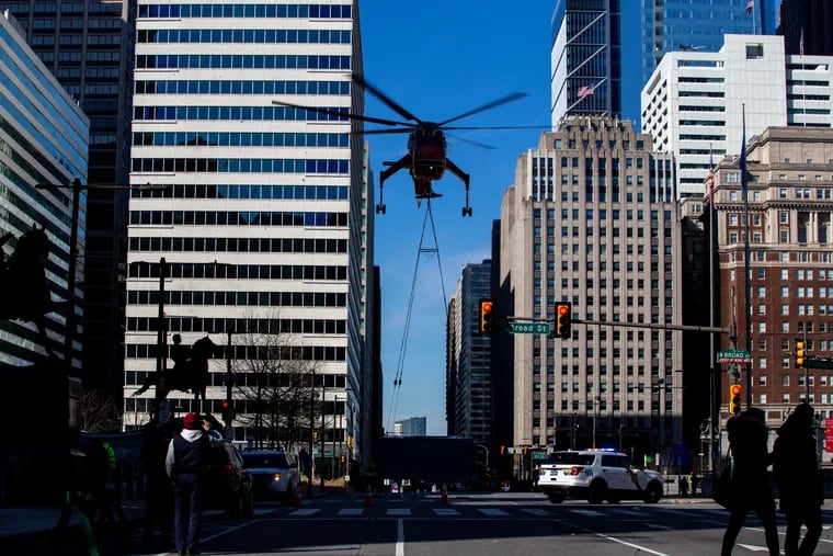 A helicopter flies over Center City, Philadelphia, while moving HVAC units to 2000 Market St., on Sunday.