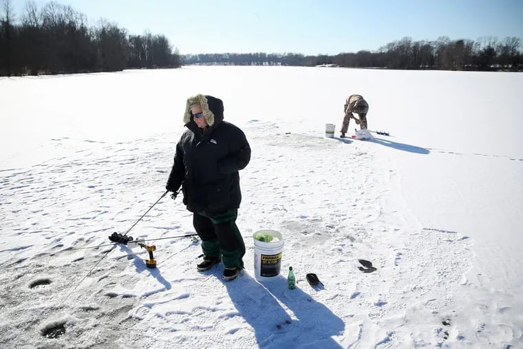 Tony Pogo of Philadelphia fishes for trout on a frozen Lake Luxembourg in Middletown Township, Pa., on Tuesday.