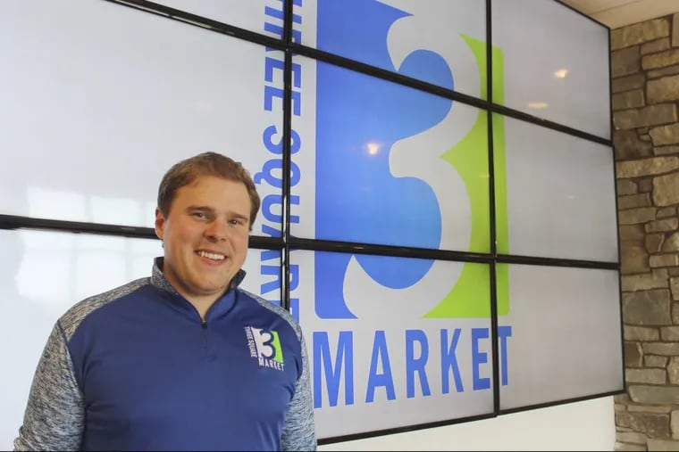 Tony Danna, vice president of international development at Three Square Market, poses in front of the company’s logo at its headquarters in River Falls, Wis. The software company is offering to microchip its employees, enabling them to open doors, log onto their computers and purchase break room snacks with a simple wave of the hand.