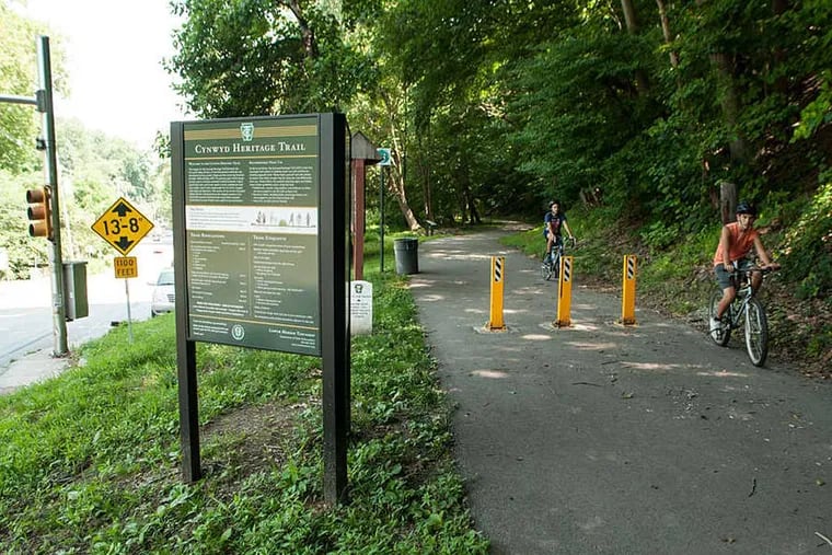 Joey Benjaima and Ari Amar bike on the Cynwyd Trail near the intersection of Rock Hill Road and Belmont Avenue in Lower Merion Township. A new development plan along Rock Hill Road looks to make access to the popular trail easier and safer. August 7, 2014, Lower Merion Township, Pennsylvania. ( MATTHEW HALL / Staff Photographer )