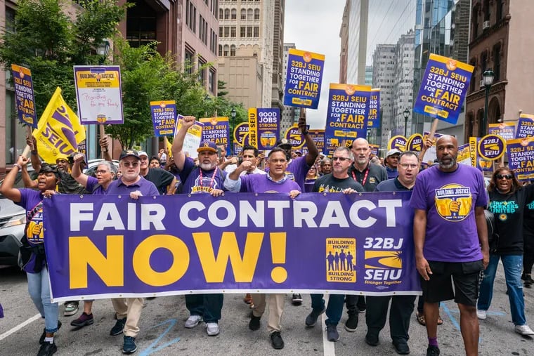 Members of SEIU Local 32BJ protest on Arch Street on Tuesday, Aug. 29, against what they describe as a reduction in hours sought by building owners for cleaners, mechanics, and other office workers.