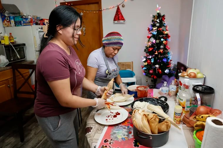 Citlalli Dominguez (left) and her mother, Juana Librado, make pork and chicken tamales in Dominiguez’s South Philadelphia apartment kitchen. Tamales are a tradition on Christmas Eve for many Mexican and Central American families.