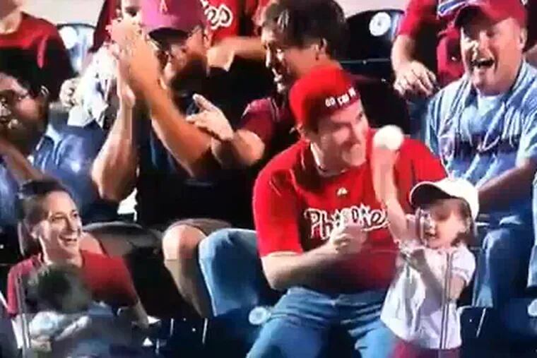 After catching a foul ball, Steve Monforto hands it to his daughter, Emily, 3 -- and she throws it back. The toss and loss happened during the fifth inning on Sept. 15, 2009, at Citizens Bank Park. (Image from a YouTube video.)