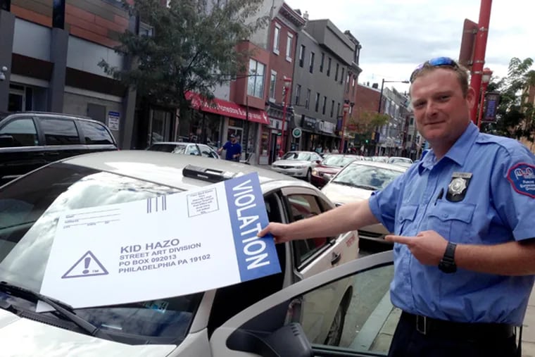 Philadelphia Parking Authority officer T. Free finds Kid Hazo’s prank ticket on his windshield on South Street on Sept. 22, 2013. (Melissa Dribben / INQUIRER)
