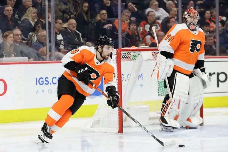 Flyers defenseman Ivan Provorov moves the puck down the ice as goaltender Carter Hart watches in a Jan. 13 game against the Boston Bruins.