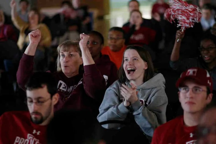 Steph Roman, Class of 2003, and her mother, Marj, watch the Temple women on a big screen in Mitten Hallon campus.