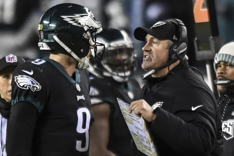 Eagles coach Doug Pederson giving quarterback Nick Foles instructions during the game against the Raiders.