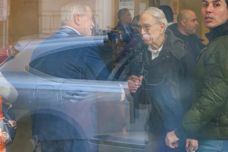 Defense attorney Karl Schwartz (left), shaking hands with Theodore Tapper, the Philadelphia physician who helped exonerate C.J. Rice, photographed through a window at the Juanita Kidd Stout Center for Criminal Justice on Monday.