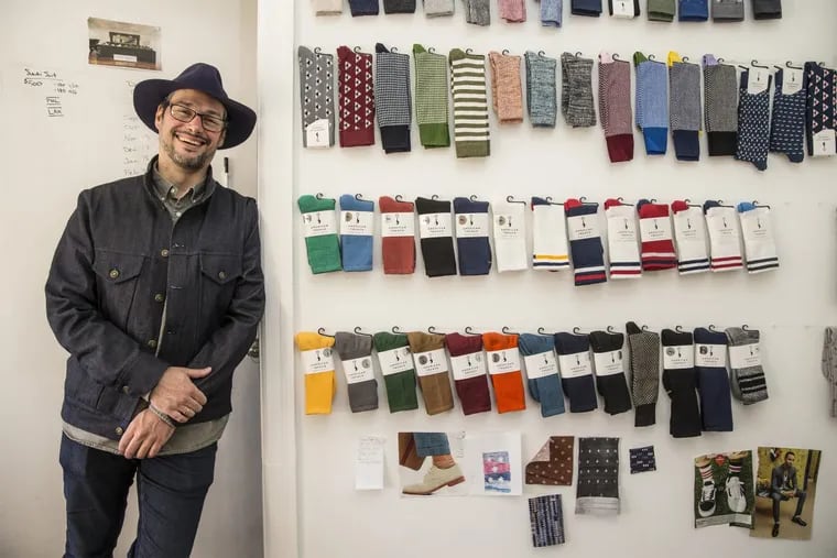 Jacob Hurwitz, cofounder of American Trench, with the spring line of socks and modeling some of the company’s new Made In Phila line to promote other local clothing manufacturers.