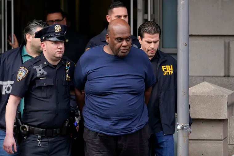 New York City Police and law enforcement officials lead subway shooting suspect Frank James, center, away from a police station on April 13. On Friday, a federal grand jury indicted James in the attack that wounded multiple people and rattled a city already experiencing a rise in violent crime.