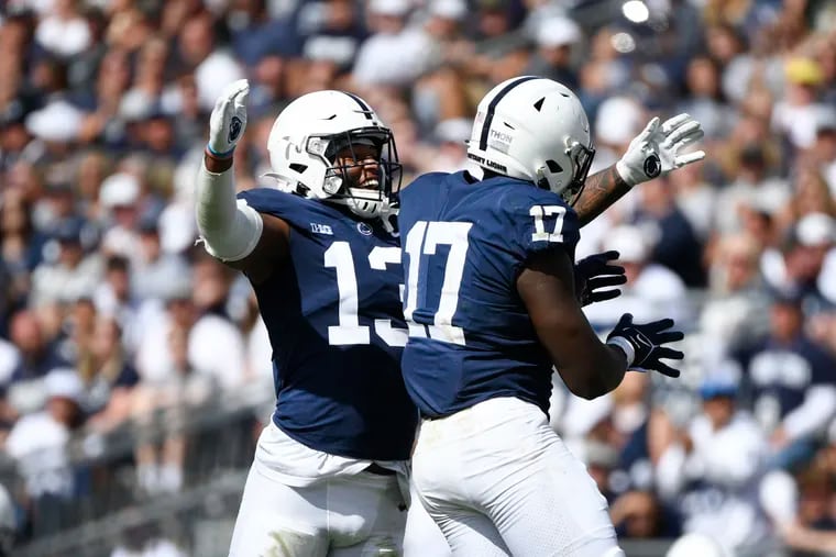Ellis Brooks (13), Arnold Ebiketie (17) and the Penn State defense will be challenged by stopping a potent Michigan run game on Saturday.