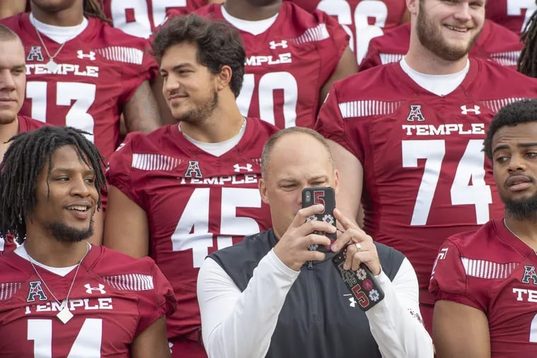 OWLSFB03-b.Temple University Head Football Coach Geoff Collins takes a picture of photographer Zamani Feelings as he set up the team photo at the Philadelphia Museum of Art on Thursday August 2, 2018 . On the left is Wide Receiver Brodrick Yancy, 14, and on the right is Safety Delvon Randall.(Jonathan Wilson / For the Inquirer)