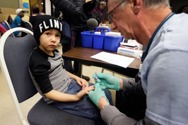 A nurse draws a blood sample from Grayling Stefek, 5, in Flint, Mich. Health advocates say Philadelphia’s testing underestimates the amount of lead in plumbing.
