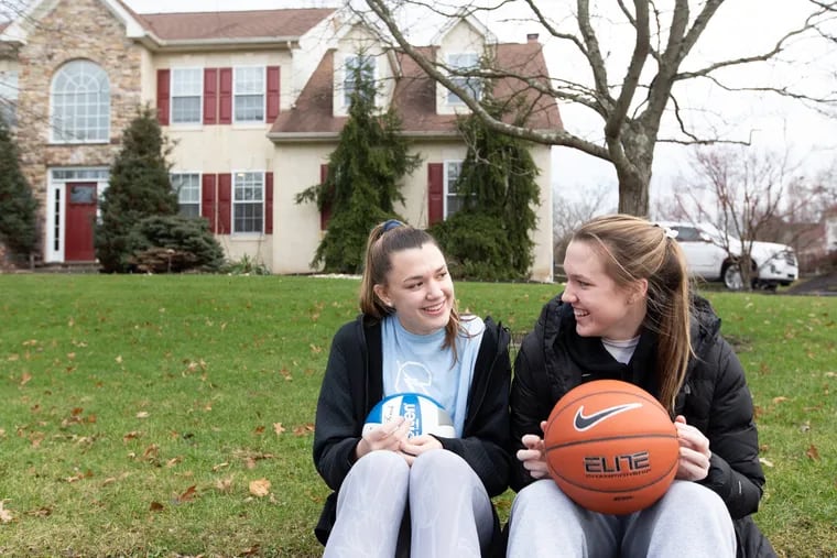 Maddie Burke (right), sits with her twin sister, Allie, in front of their dad's house in Doylestown. Maddie plays basketball for Central Bucks West, and Allie plays volleyball for Central Bucks South.