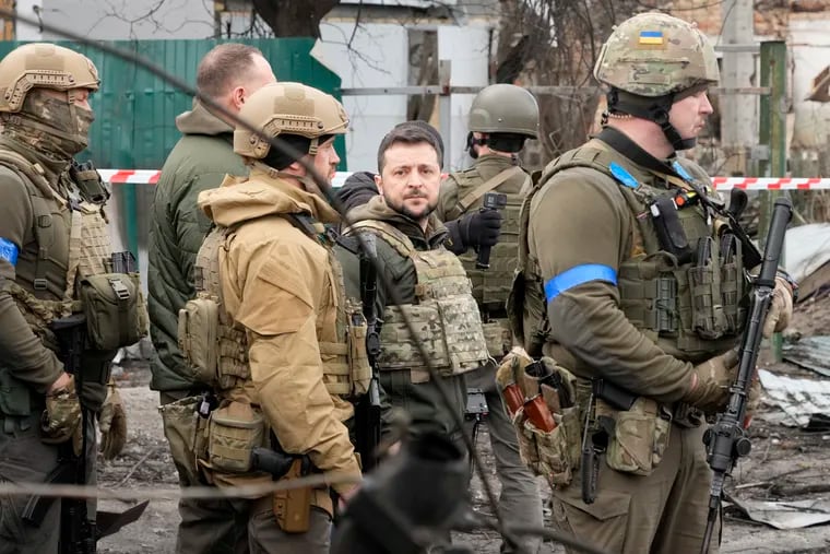Ukrainian President Volodymyr Zelenskyy (center) examining the site of a recent battle in Bucha, close to Kyiv, Ukraine, on Monday.