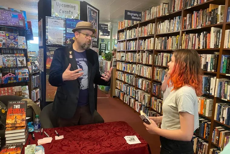 "Two Degrees" author Alan Gratz chats with 14-year-old reader Calliope Price at the Firefly Bookstore in Kutztown on Saturday. Conservative school board members had successfully blocked the book from a reading program at a middle school in the Berks County community.