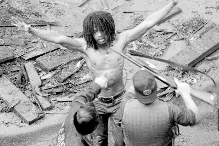 MOVE member Delbert Africa surrenders 8/8/1978 to police after a shoot out at MOVE headquarters in Philadelphia. James G. Domke / Inquirer Staff Photographer