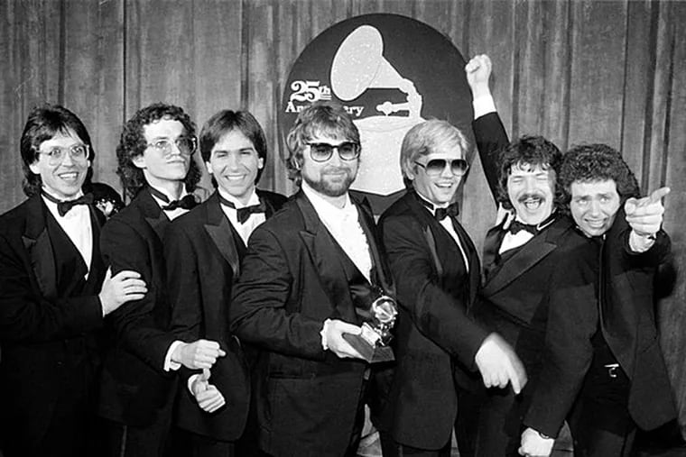In this Feb. 23, 1983 file photo, band members, from left, Jeff Porcaro, Steve Porcaro, Michael Porcaro, Dave Paich, Dave Herngate, Bobby Kimball and Steve Lukather, of Toto pose after winning six Grammys during the 25th Annual Grammy Awards presentation in Los Angeles. Mike Porcaro, who was the son and brother of prominent musicians and carved out a long, successful career as the bass player for the Grammy-winning pop group Toto, has died at age 59. Porcaro died Sunday, March 15, 2015, Toto's publicist Keith Hagen told The Associated Press. (AP Photo, File)