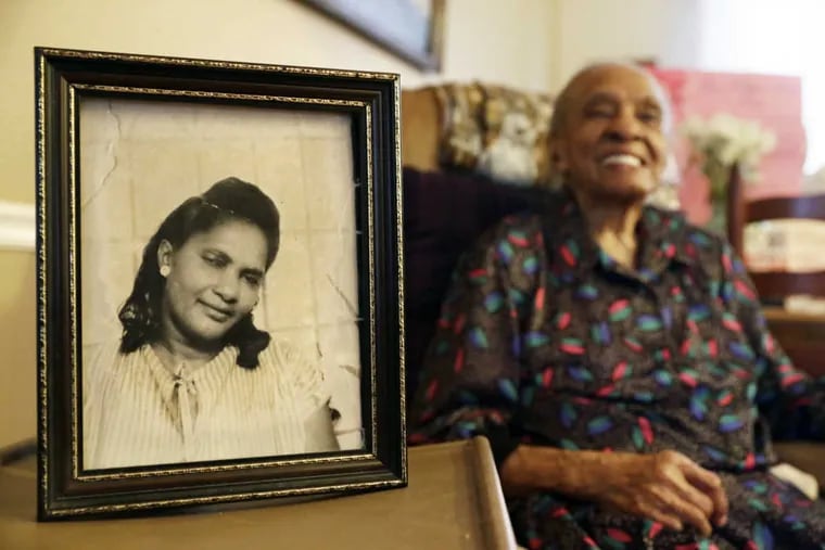 Barnetta Williams, who is 109 years old, sits next to a picture of herself that was taken when she was 33.