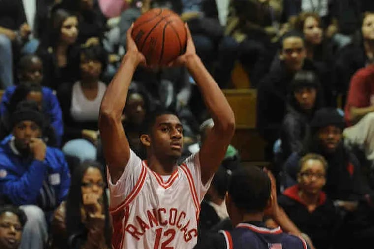 Kenny Johnson of Rancocas Valley looks for the open man as Willingboro's Dominic Cain gets set to react.