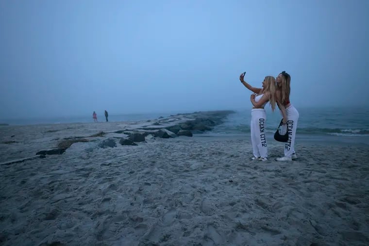 Bryanna Snell (left) and Kylie Spickenreuther of Vineland pose for selfies on the Ocean City beach around 8:30 pm on Memorial Day weekend, Sunday, May 26, 2024. Even though the beach was technically to be closed at 8 pm, Spickenreuther said “instagram comes first”.